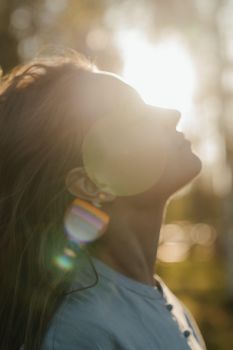 Mehr Ruhe im Alltag: Sonne genießen. Zu sehen ist eine Frau, die ihr Gesicht in die Sonnenstrahlen hält.