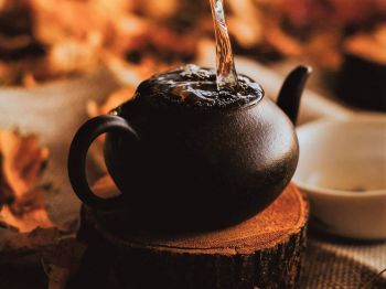 Wärmende Getränke: zu sehen ist eine Teekanne, in die heißes Wasser gegossen wird.